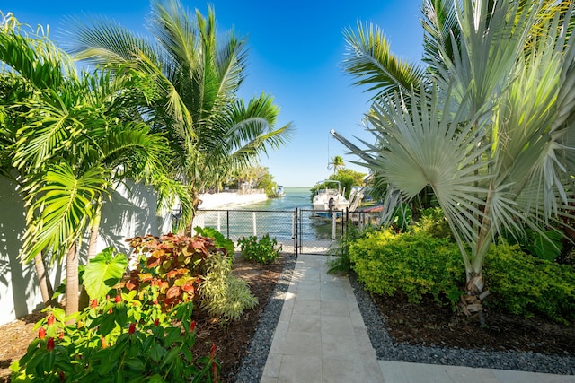 view of property's community featuring a gate, a water view, and fence