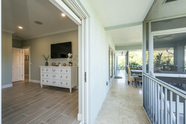 corridor featuring recessed lighting, crown molding, baseboards, and wood finished floors