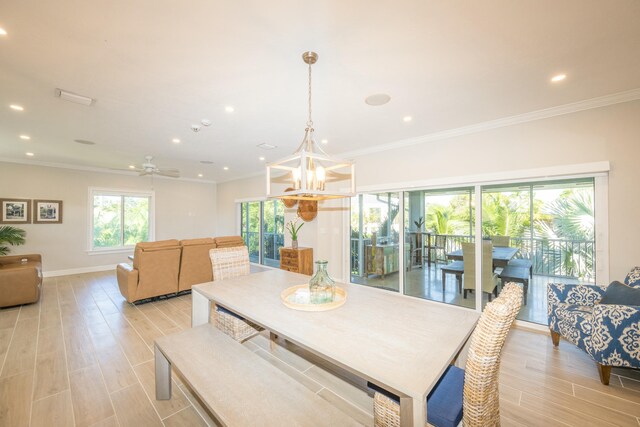 dining space featuring ornamental molding, light hardwood / wood-style floors, and a notable chandelier