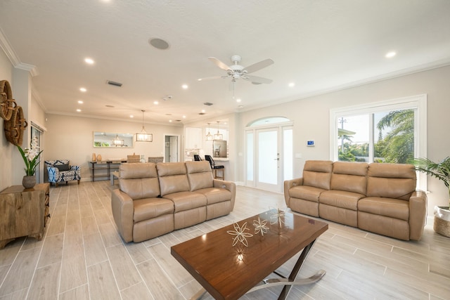 living room with ornamental molding and ceiling fan