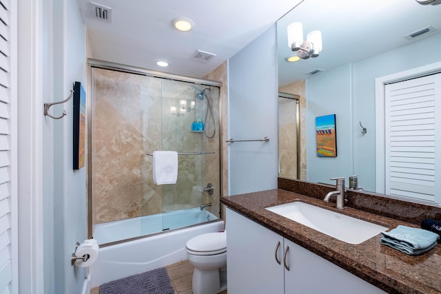 full bathroom featuring vanity, enclosed tub / shower combo, and toilet