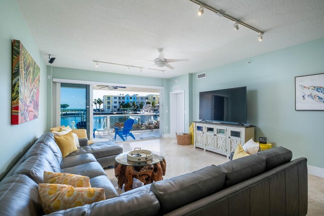 living room with ceiling fan and a textured ceiling