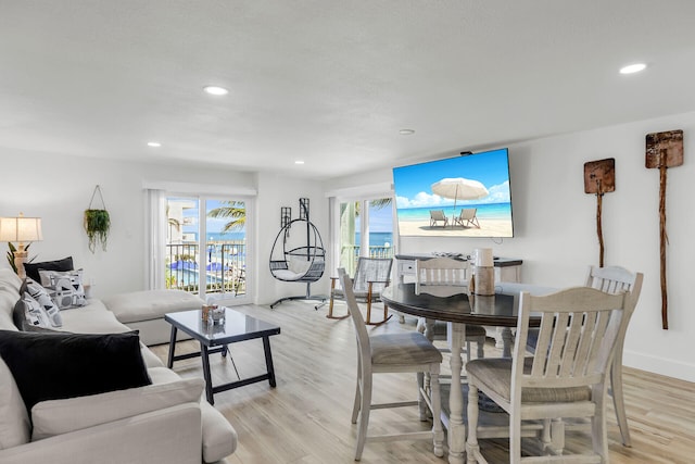 living area featuring recessed lighting, baseboards, and light wood finished floors