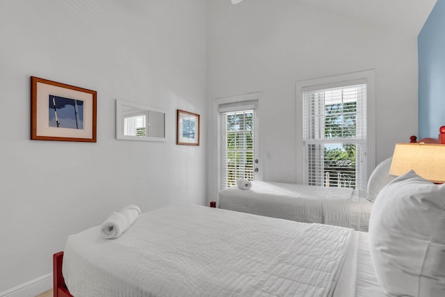 bedroom featuring access to exterior and high vaulted ceiling