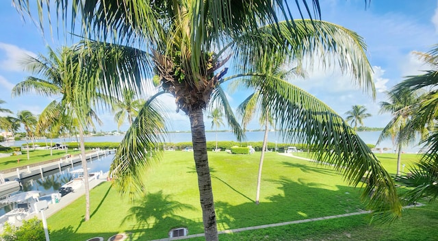 view of property's community with a lawn and a water view