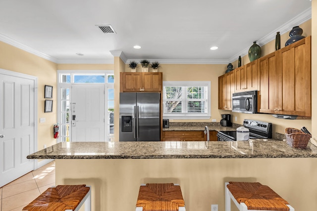 kitchen featuring stainless steel appliances, a kitchen bar, and kitchen peninsula