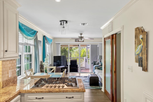 kitchen featuring crown molding, stainless steel gas stovetop, and white cabinets