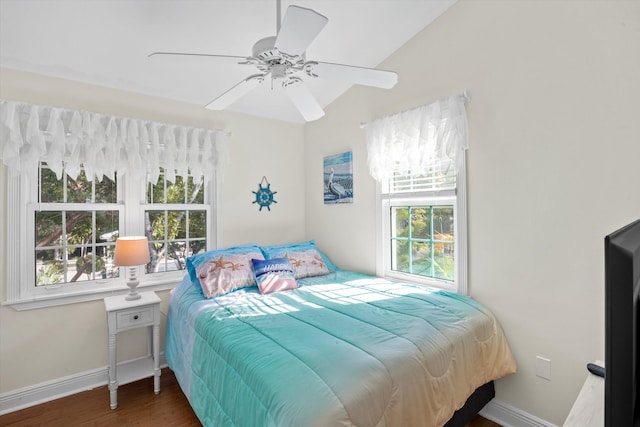 bedroom with ceiling fan, lofted ceiling, dark hardwood / wood-style flooring, and multiple windows