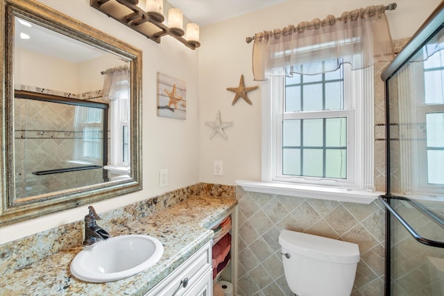 bathroom with vanity, tile walls, an enclosed shower, and toilet