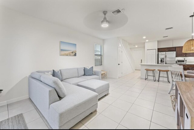 living room featuring light tile patterned flooring and ceiling fan