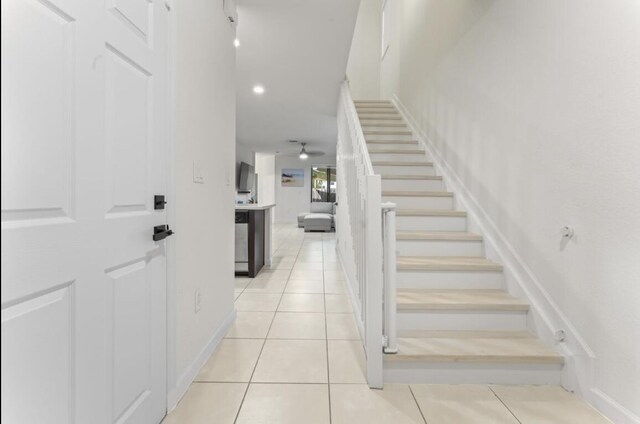 stairs with ceiling fan and tile patterned flooring