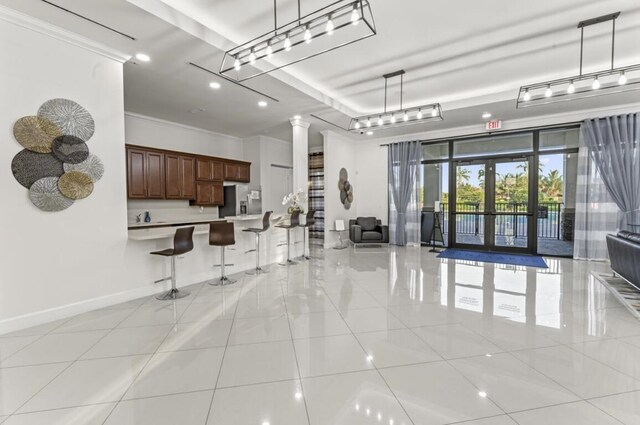 kitchen with stainless steel refrigerator with ice dispenser, decorative light fixtures, and decorative columns