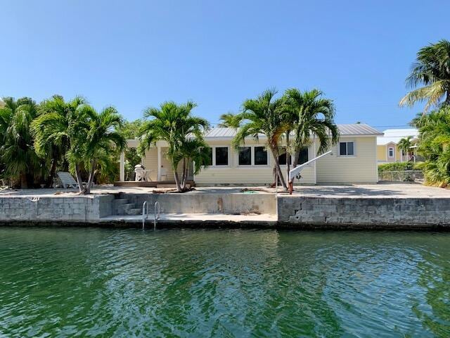 back of property featuring a water view and a patio area