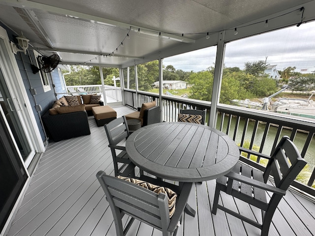 wooden terrace featuring outdoor dining space, outdoor lounge area, and a water view