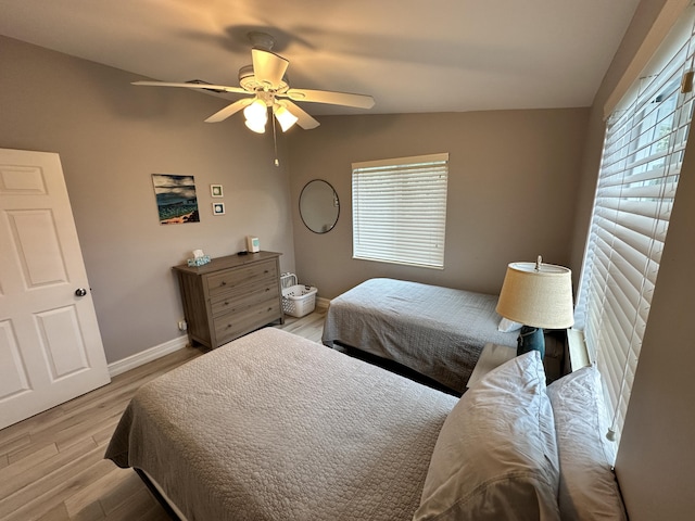 bedroom featuring ceiling fan, wood finished floors, and baseboards