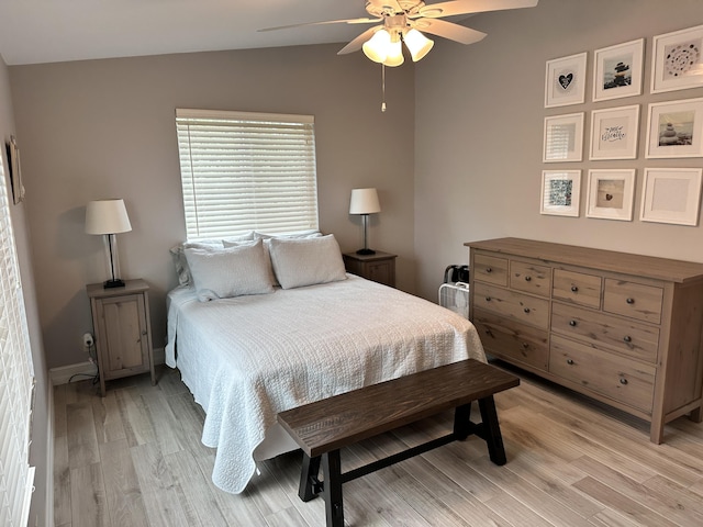 bedroom featuring a ceiling fan, lofted ceiling, and light wood finished floors