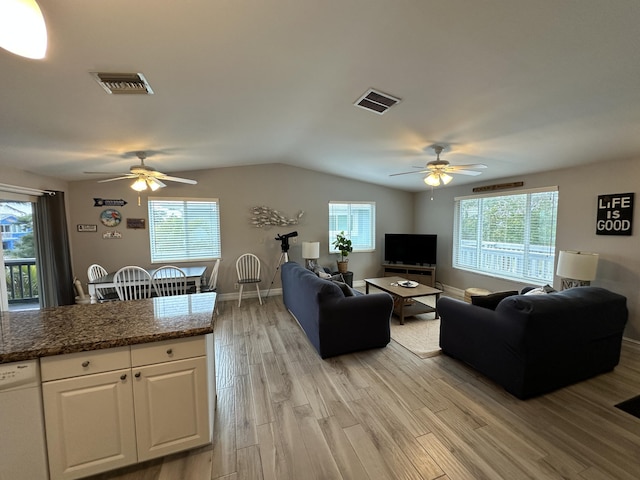 living room featuring light wood-type flooring, baseboards, visible vents, and vaulted ceiling