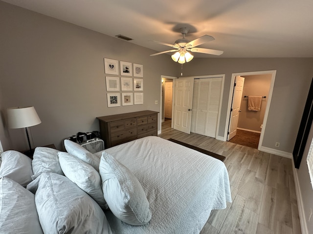 bedroom with wood finished floors, a ceiling fan, visible vents, baseboards, and a closet