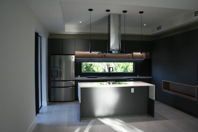 kitchen featuring stainless steel fridge with ice dispenser, decorative light fixtures, sink, and a raised ceiling