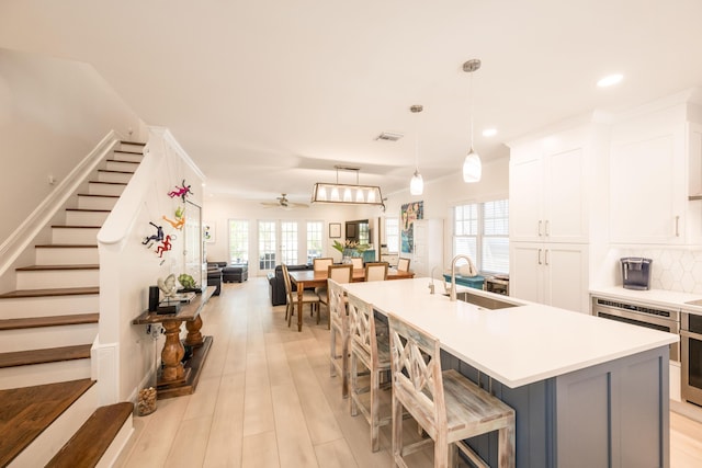 223 Golf Club Dr, Key West, FL 33040 - kitchen with backsplash, a sink, white cabinetry, and plenty of natural light