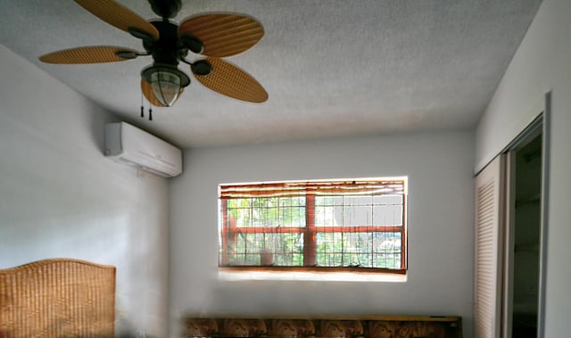 unfurnished bedroom with a closet, ceiling fan, a textured ceiling, and a wall mounted AC