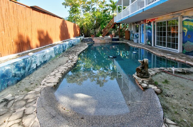 view of pool featuring stairs, fence, and a fenced in pool