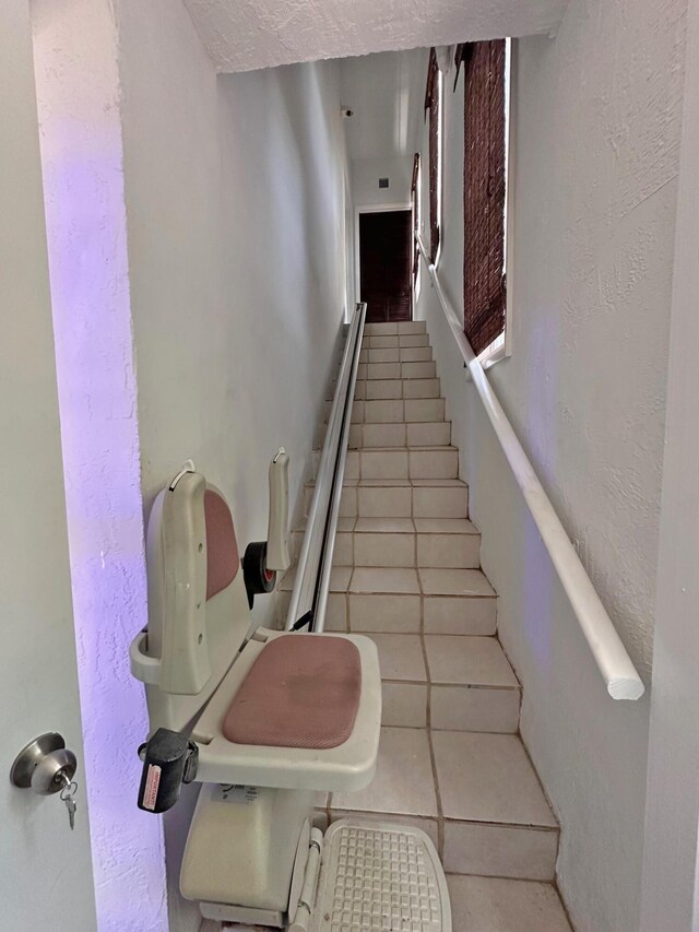 full bath featuring a sink, a healthy amount of sunlight, tile walls, and a closet