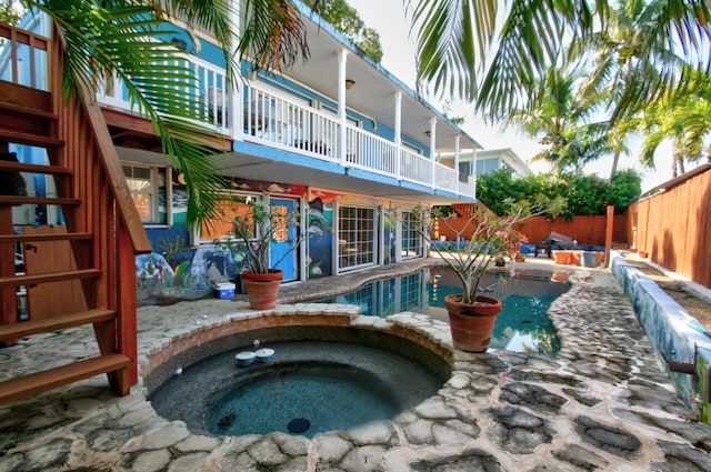 outdoor pool featuring a fenced backyard and an in ground hot tub