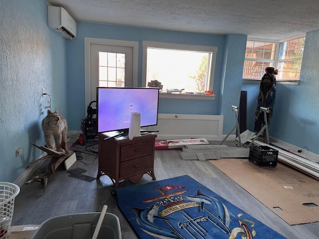 interior space with hardwood / wood-style flooring, radiator, a textured ceiling, and an AC wall unit