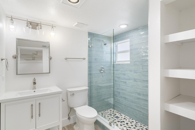 full bath featuring visible vents, a tile shower, vanity, and toilet