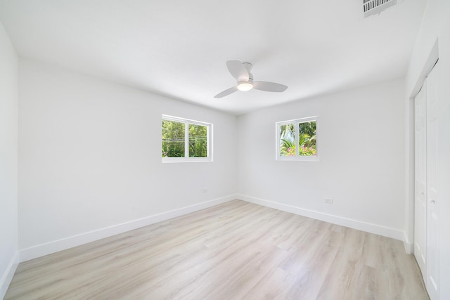 unfurnished bedroom with baseboards, visible vents, a ceiling fan, light wood-style flooring, and a closet