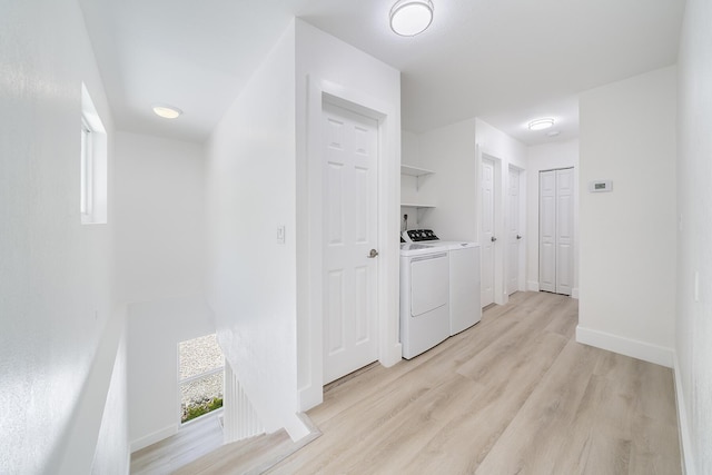 washroom with baseboards, laundry area, light wood finished floors, and washer and dryer