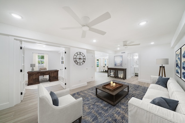 living room featuring light wood finished floors, baseboards, and recessed lighting