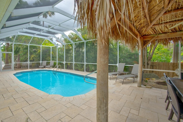 view of swimming pool featuring a patio and a lanai