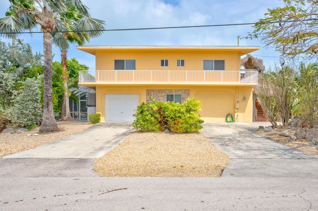 raised beach house with a balcony and a garage