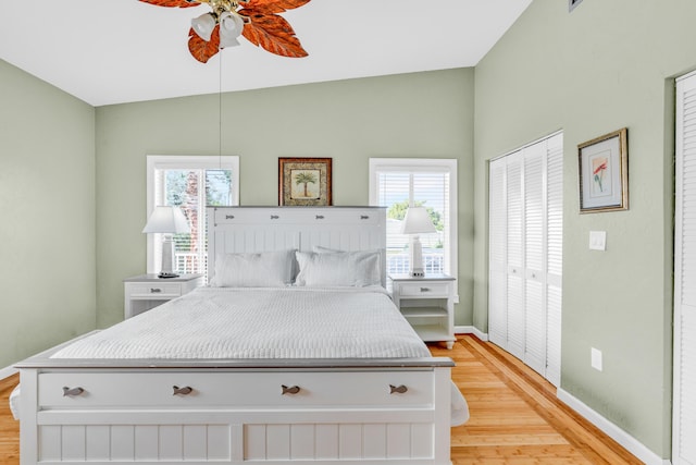 bedroom featuring multiple windows, lofted ceiling, and light hardwood / wood-style floors