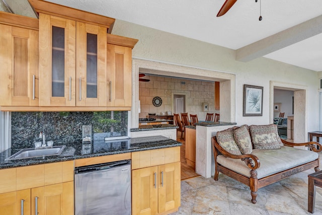 kitchen with sink, dark stone countertops, dishwasher, ceiling fan, and decorative backsplash