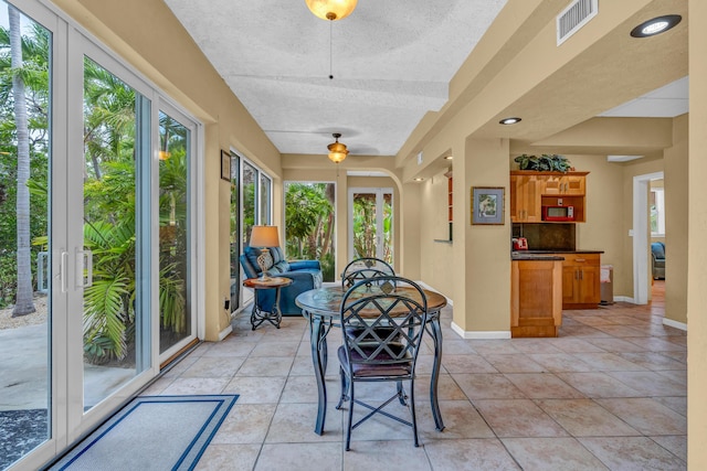 sunroom / solarium featuring ceiling fan