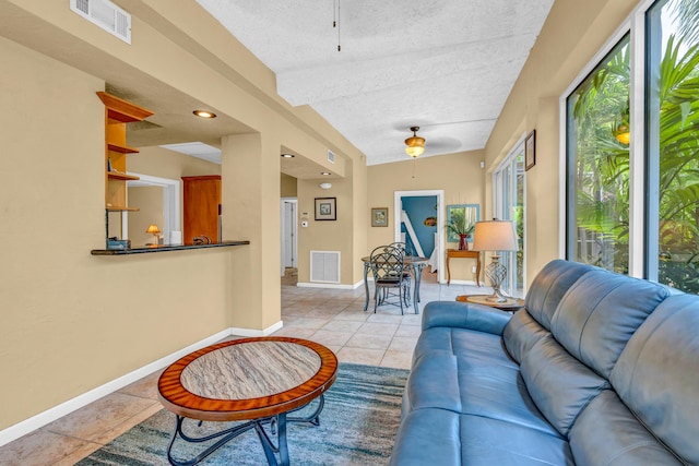 tiled living room featuring a textured ceiling and ceiling fan