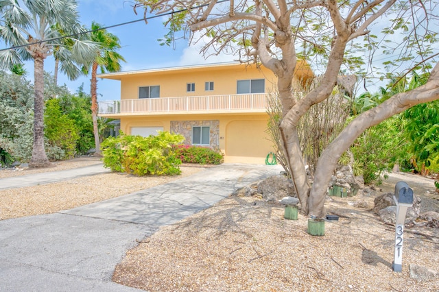 view of front of home featuring a balcony and a garage