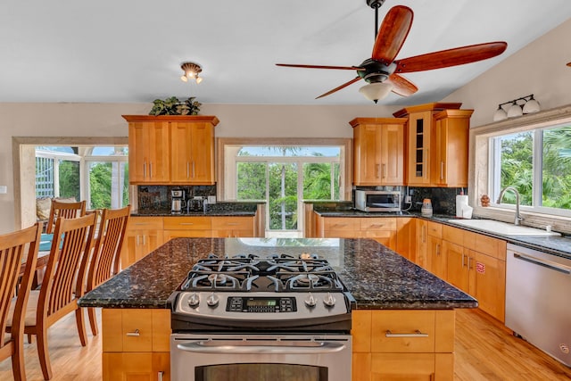 kitchen with stainless steel appliances, sink, a kitchen island, and backsplash