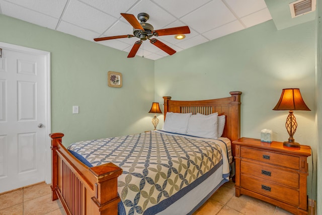 bedroom with light tile patterned floors, a paneled ceiling, and ceiling fan