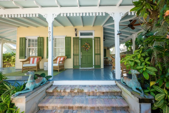 doorway to property with covered porch and a ceiling fan