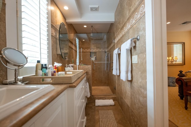 full bath with double vanity, a shower stall, visible vents, and a sink