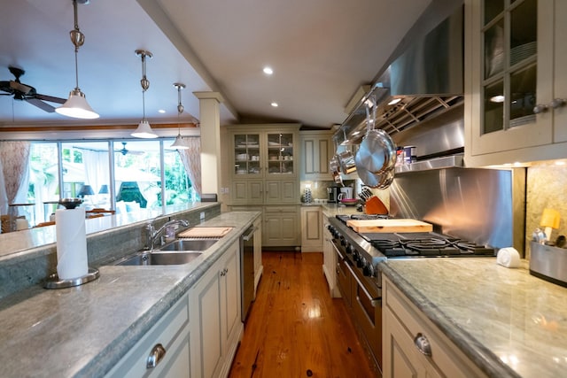 kitchen featuring decorative light fixtures, light wood finished floors, tasteful backsplash, a sink, and dishwasher