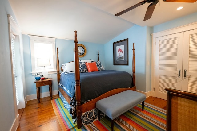 bedroom with a closet, baseboards, vaulted ceiling, and wood finished floors