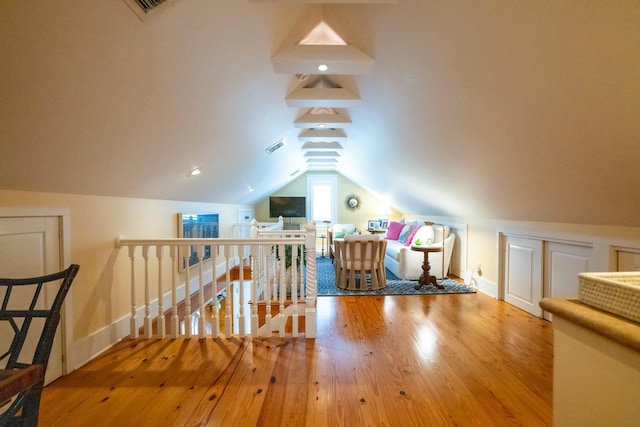 bonus room with visible vents, vaulted ceiling, baseboards, and wood finished floors