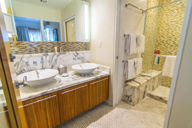 bathroom with vanity, decorative backsplash, a shower with door, and tile patterned floors