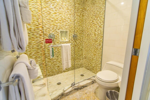 bathroom with toilet and a shower with shower door