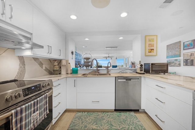kitchen featuring visible vents, a toaster, light stone countertops, a sink, and stainless steel appliances